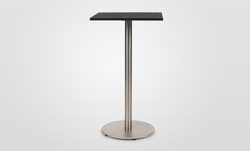 A Stylus bar table with black cork table top on a polished stainless steel pedestal base