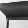 A close up of a black plastic chair on a white background.