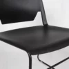 A black plastic chair against a white background.