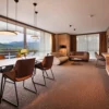 A living room in a hotel with mountains in the background.