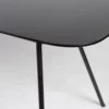 A black glass dining table with black legs.