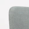 A close up of a chair with a light blue fabric.