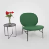 A green chair next to a table with flowers.