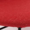 A close up of a red chair with a black frame.