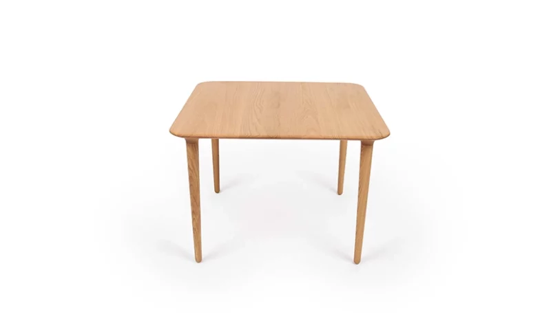 A simple wooden table with four legs on a white background.