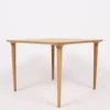 A simple wooden table with four slender legs on a plain white background.