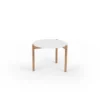 A simple three-legged table with a white top on a white background.