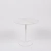 A modern round marble-top table with a single white pedestal base against a plain background.