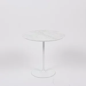 A modern round marble-top table with a single white pedestal base against a plain background.