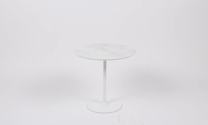 A modern round marble-top table with a single white pedestal base against a plain background.