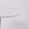 A round marble tabletop on a single central leg against a white background.