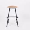 A modern bar stool with a wooden seat and black metal legs on a white background.