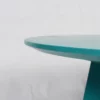 Edge of a teal table against a white background.