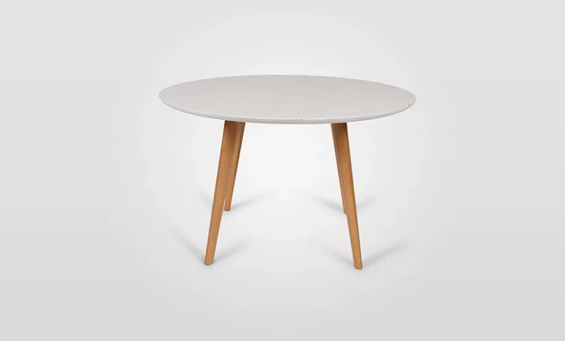 A modern round table with a white top and wooden legs on a white background.