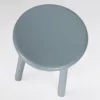 A simple blue stool with three legs on a white background.