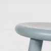 Edge of a blue stool against a white background.