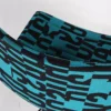 Turquoise and black patterned fabric with a curved shape and visible seams.