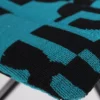 Close-up of a turquoise and black checkered cloth with a textured surface.