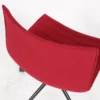 Modern red fabric chair with a curved design on a white background.