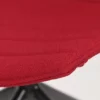 Close-up of the edge of a red fabric chair against a white background.