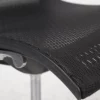 Close-up of a black mesh office chair with a focus on the texture and adjustment lever.