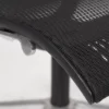 Close-up of a black ergonomic office chair seat with mesh fabric and adjustment lever.