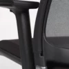 Close-up view of an ergonomic office chair armrest and mesh backrest.