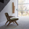 A Toggle lounge armchair by Prostoria, featuring wooden arm and legs in Oak, within a small study nook.
